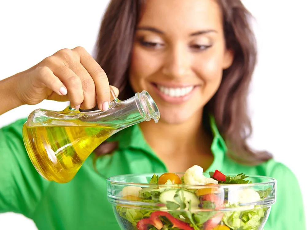 Bottiglia di olio extravergine d'oliva versato, simbolo dello studio sul suo ruolo nella prevenzione dei tumori