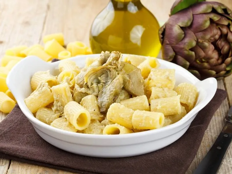 Pasta con carciofi sott'olio e panna fatta in casa servita a tavola