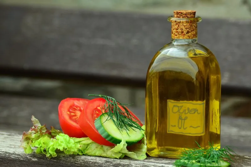 Bottiglia e frutti di olivo, simbolo della qualità dell'olio extravergine