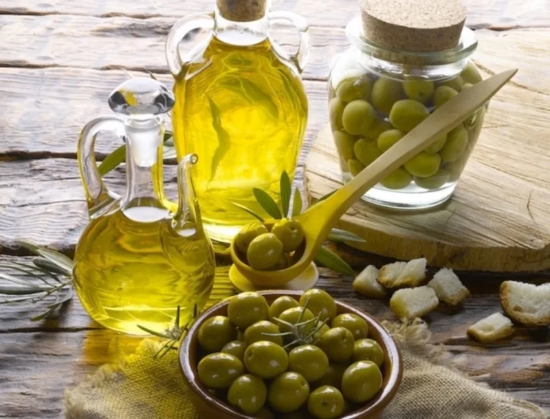 Bottiglia di olio extravergine di oliva accanto ad attrezzi da palestra