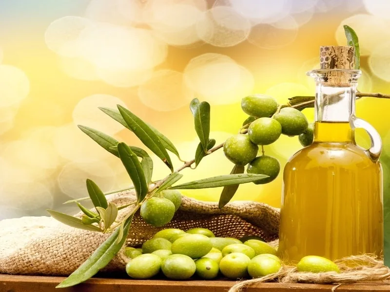 Bottiglia di olio dal colore pallido a confronto con l'olio extravergine di oliva
