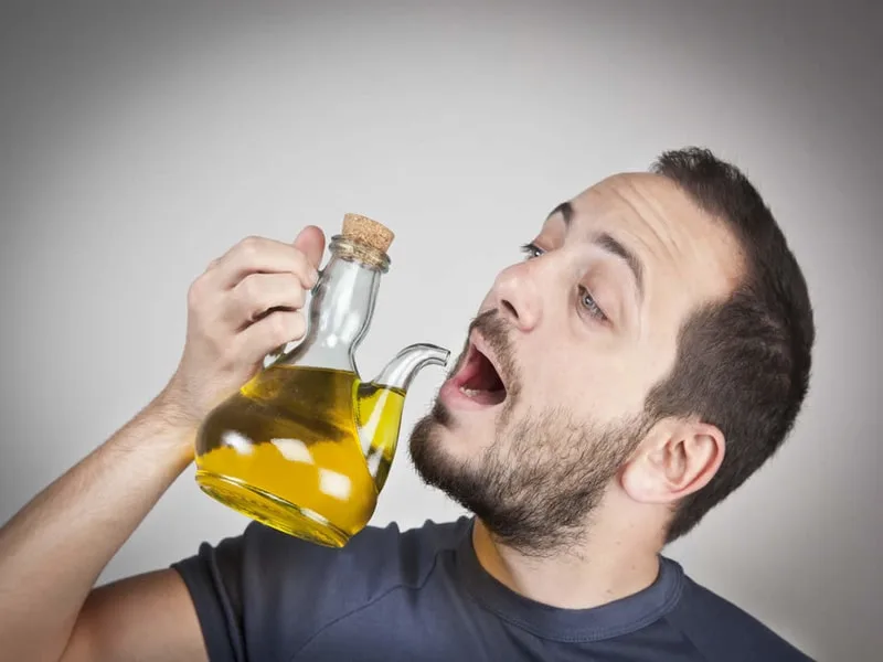 Bottiglia di olio extravergine d'oliva versato, simbolo dello studio su olio evo e salute maschile