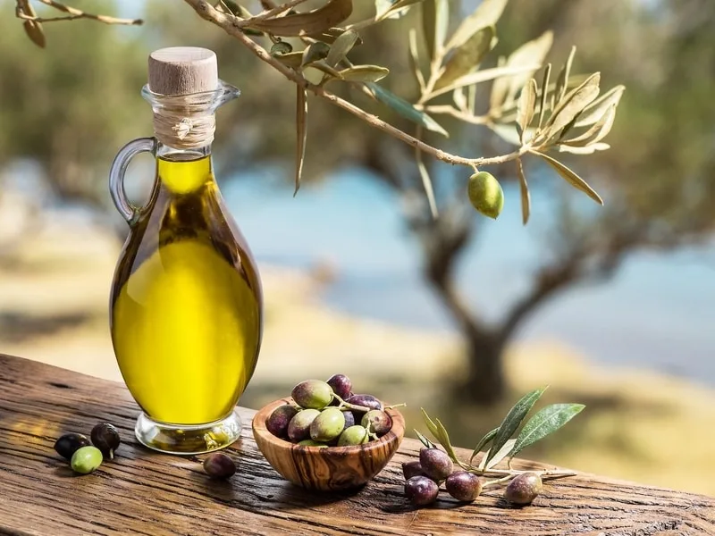 Cucchiaio di olio extravergine di oliva versato in una ciotola, simbolo del giusto consumo quotidiano