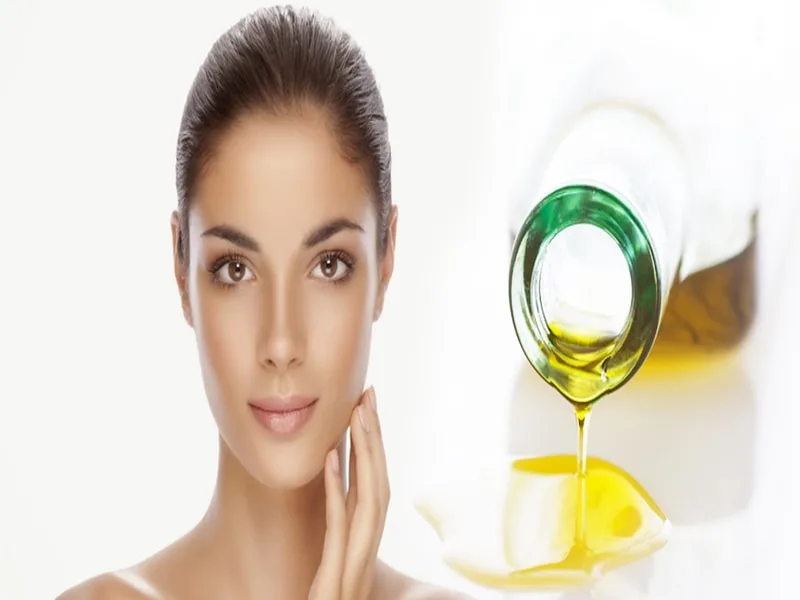 Goccia di olio extravergine d'oliva applicata sulla pelle del viso come rimedio naturale per la rosacea