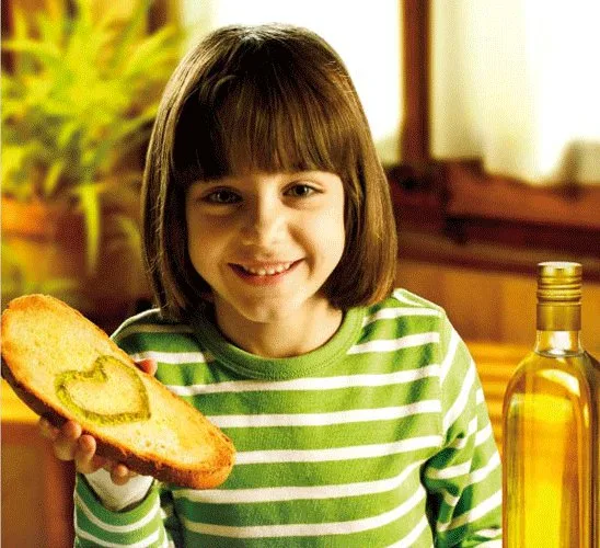 Bambino durante lo svezzamento con un cucchiaio di olio extravergine di oliva