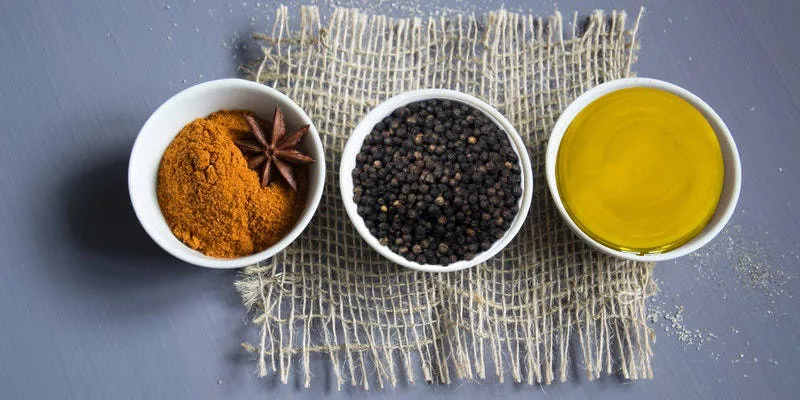 Olio extravergine di oliva macerato con curcuma e pepe nero in un flacone di vetro scuro