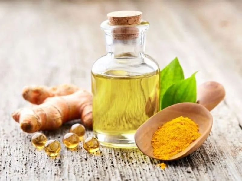 Olio extravergine di oliva versato in un contenitore di vetro, base per l'olio aromatizzato alla curcuma