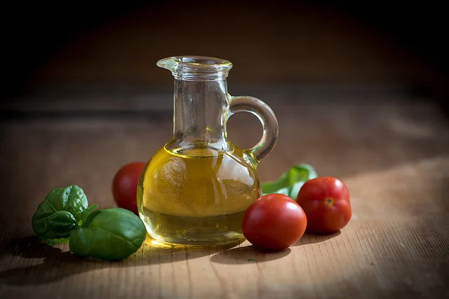 Bottiglie di olio extravergine e olio d'oliva a confronto in un frantoio pugliese