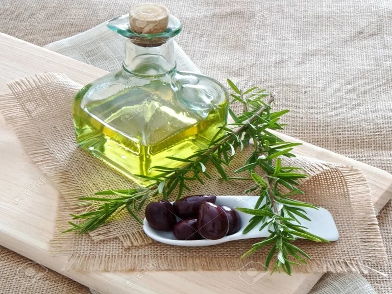 Bottiglia di olio extravergine di oliva con un rametto di rosmarino fresco
