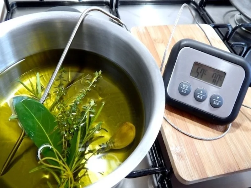 Filetti immersi in olio extravergine caldo durante la cottura in oliocottura