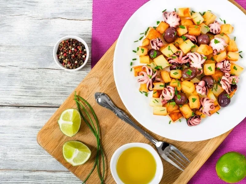 Insalata di polpo, patate e olive nere in salamoia servita fredda su un piatto