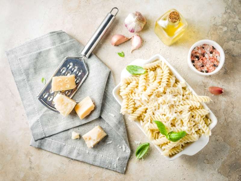 Piatto di pasta condita con olio extravergine di oliva e parmigiano grattugiato