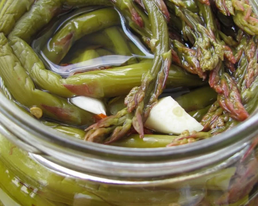 Asparagi sott'olio conservati in vasetti di vetro con olio extravergine di oliva