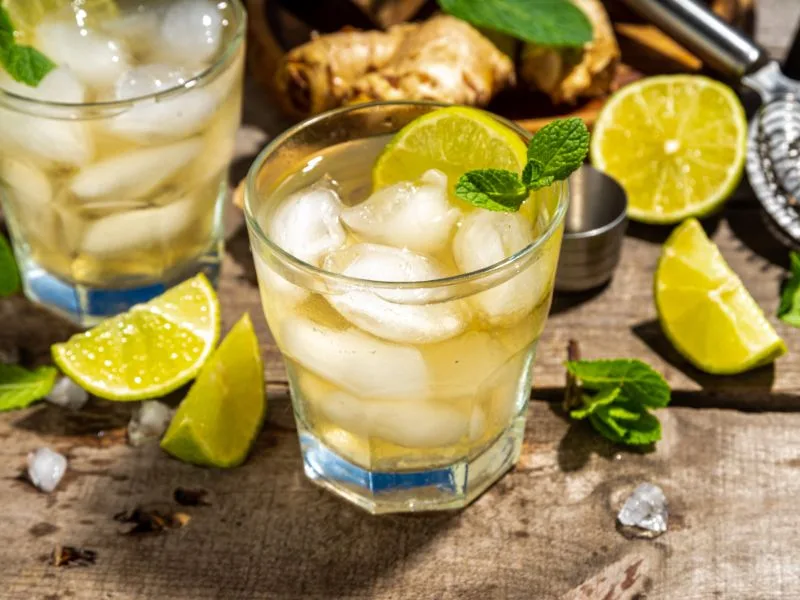 Cocktail al limone e olio extravergine di oliva servito in bicchiere elegante con fetta di limone