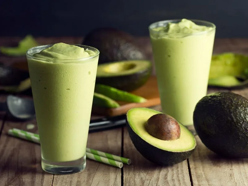 Smoothie cremoso all'avocado servito in un bicchiere con un filo di olio extravergine di oliva