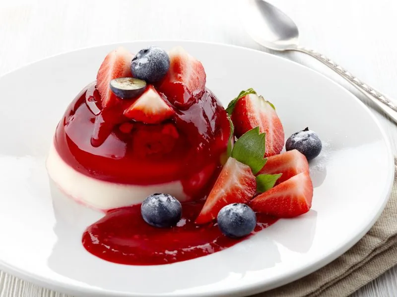 Panna cotta all'olio extravergine di oliva servita su piatto da dessert