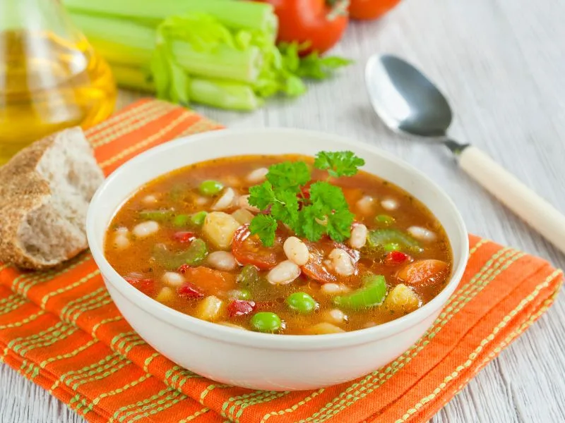 Minestrone tradizionale servito in ciotola con un filo di olio extravergine di oliva