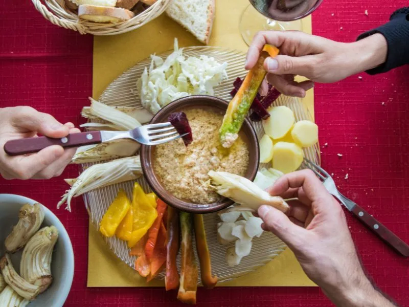 Bagna cauda calda servita con verdure fresche di stagione e olio extravergine