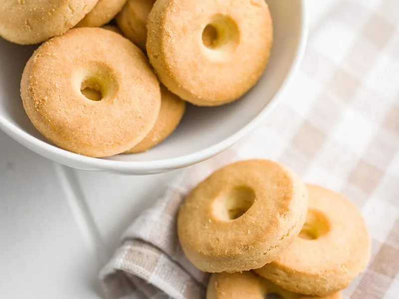 Frollini all'Olio Extravergine d'Oliva appena sfornati, disposti su carta da forno