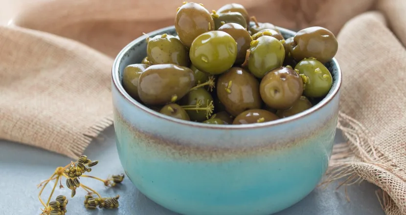 Olive verdi immerse nella soluzione di soda caustica pronte per il risciacquo