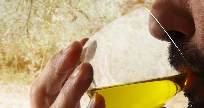 Bicchierino di degustazione con olio extravergine di oliva biologico dai riflessi dorati