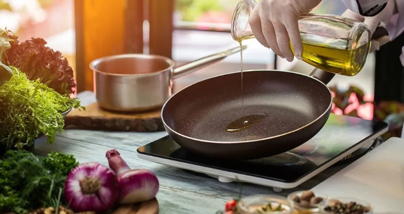 Olio extravergine biologico versato durante la preparazione di un piatto a bassa temperatura