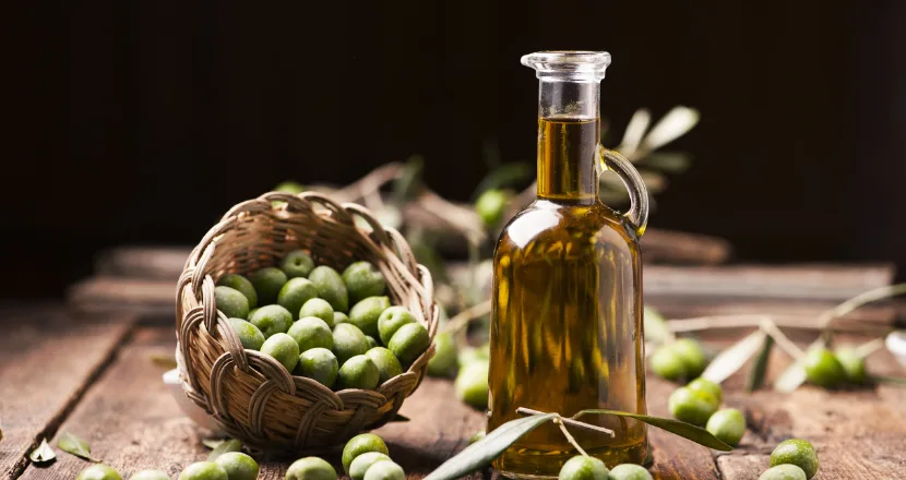 Bottiglia di olio extravergine pugliese accostata a un piatto della tradizione