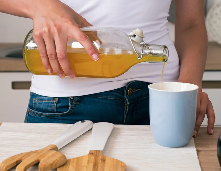 Bilancia da cucina e bottiglia d'olio usate per calcolare la conversione tra grammi e litri