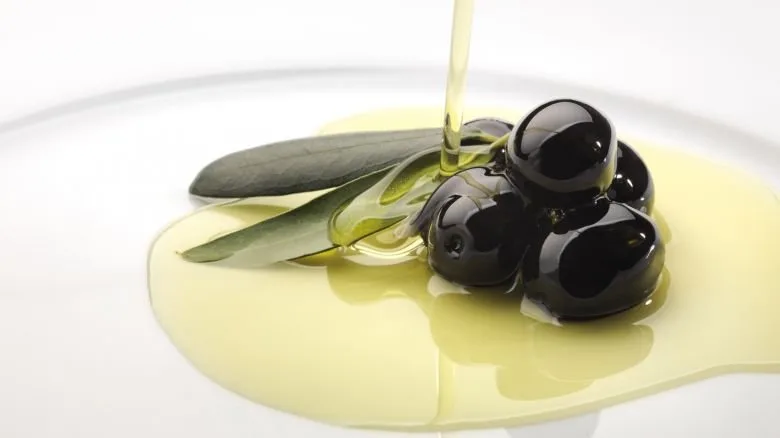 Bottiglia e frutti di olive, simbolo degli antiossidanti dell'olio extravergine