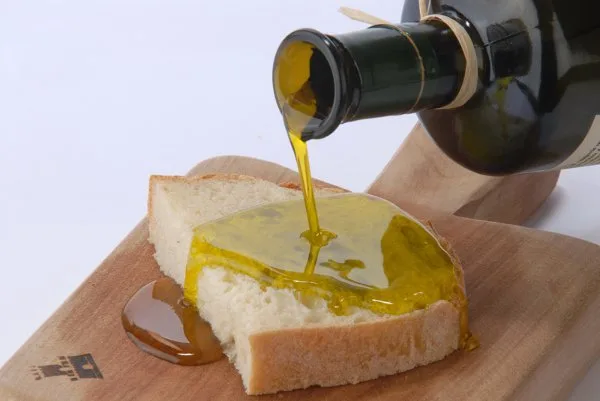 Assaggio di olio extravergine di oliva in bicchierino da degustazione