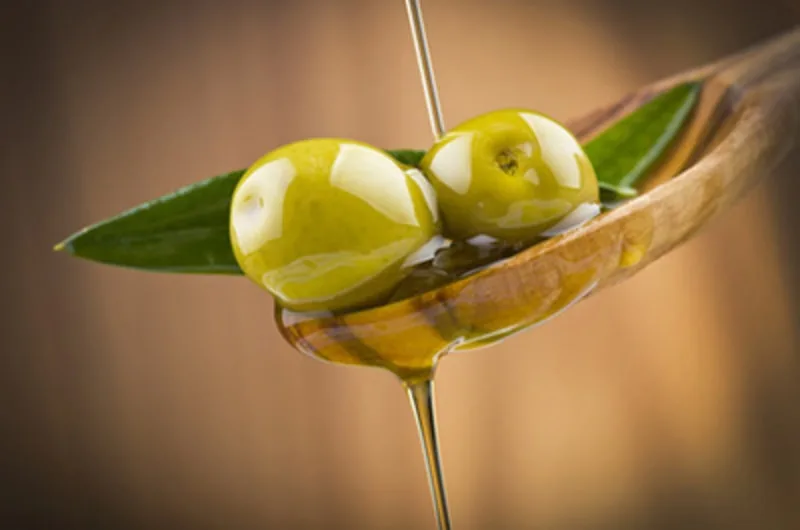 Bottiglia e cucchiaio di olio extravergine di oliva, simbolo del legame tra olio e ferro