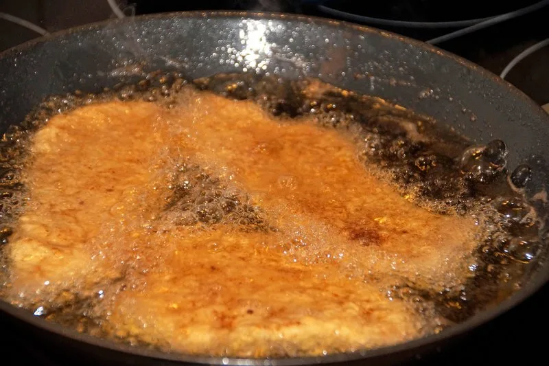 Padella con olio che raggiunge il punto di fumo durante la cottura