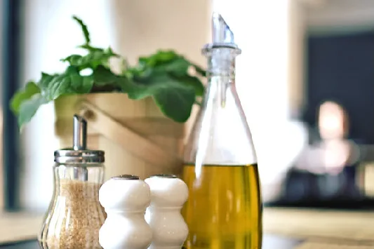 Bottiglia di olio extravergine con tappo antirabbocco su un tavolo da ristorante
