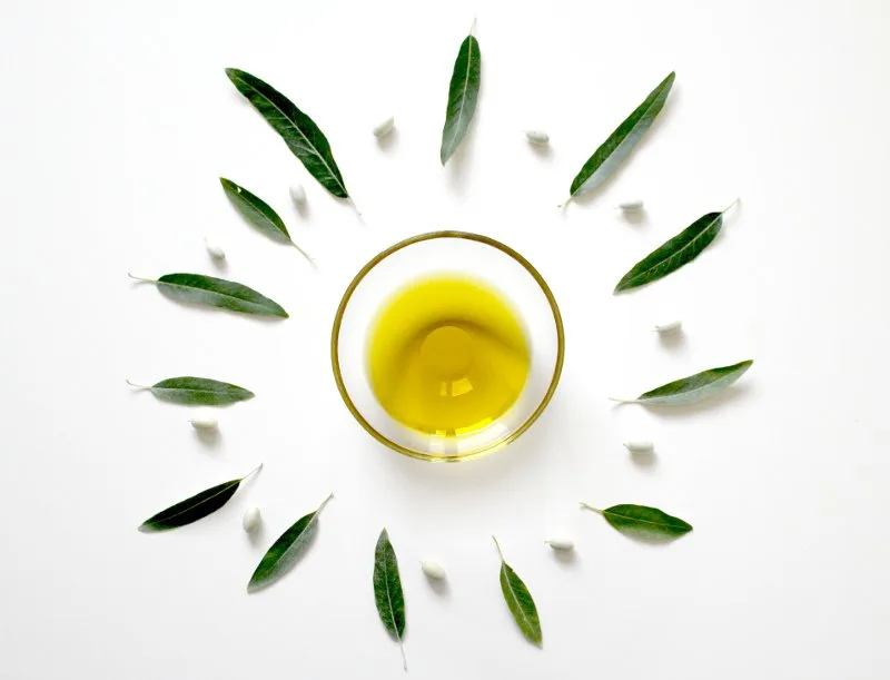 Bottiglia di olio extravergine d'oliva e olive fresche, fonte di acido linoleico