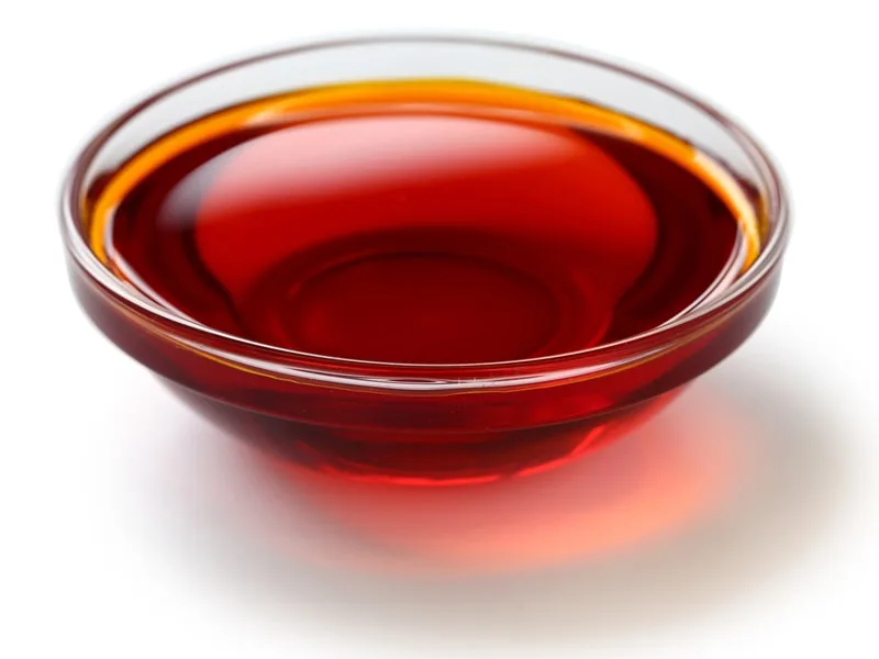 Bottiglia di olio extravergine con riflessi rossastri dovuti a ossidazione