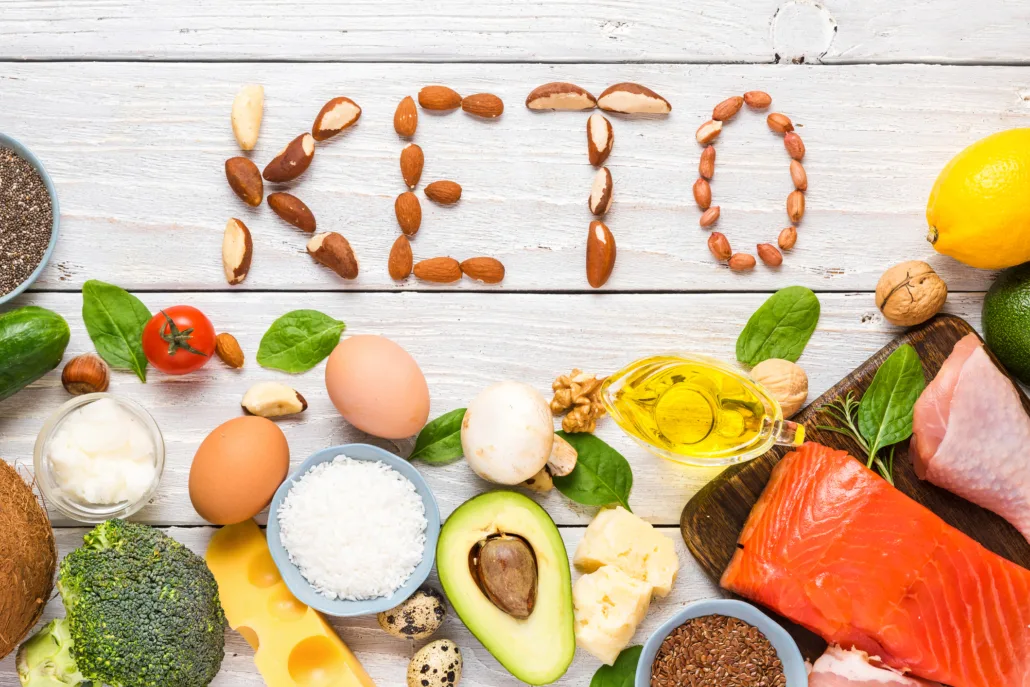 Bottiglia di olio extravergine di oliva accanto ad alimenti tipici della dieta chetogenica