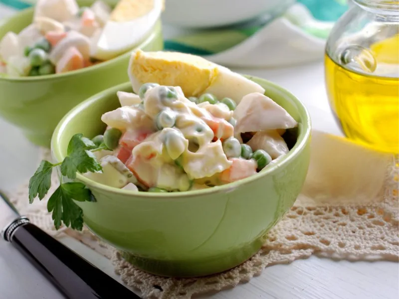 Ciotola di insalata russa condita con olio extravergine di oliva