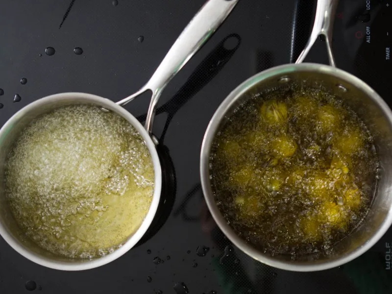 Olio extravergine di oliva versato in padella durante la cottura