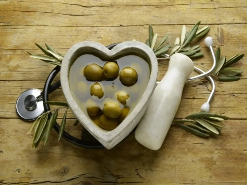 Cucchiaio di olio extravergine d'oliva versato, simbolo del suo nuovo status di alimento medicinale