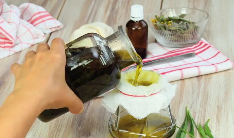 Bottiglia di olio d'oliva scaduto affiancata da un panno e da un limone per il riutilizzo domestico
