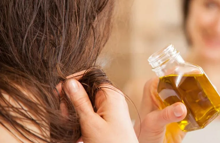 Olio d'oliva versato come trattamento naturale per i capelli