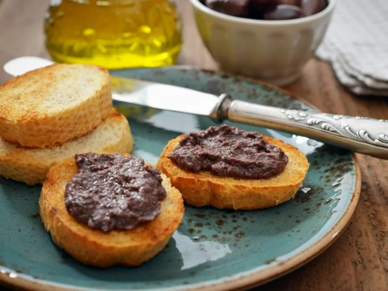 Paté di olive nere servito su crostini di pane