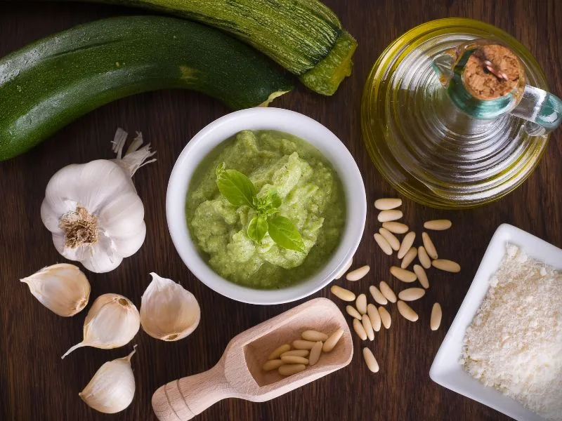 Pesto di zucchine con olio extravergine d'oliva in una ciotola, pronto per condire la pasta