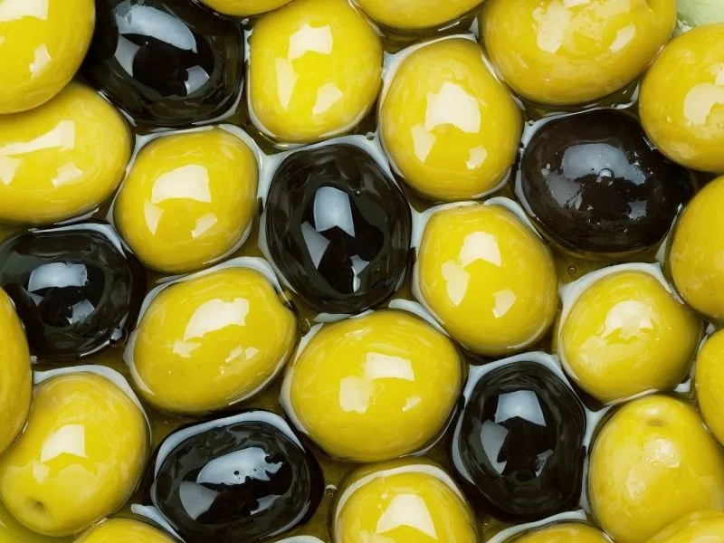 Olive verdi e nere pronte per la preparazione in salamoia con aceto