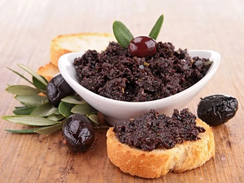 Tapenade alle olive nere servita in una ciotola con un filo di olio extravergine