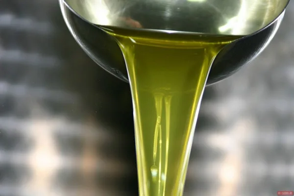 Olio extravergine spremuto a freddo versato in una bottiglia di vetro
