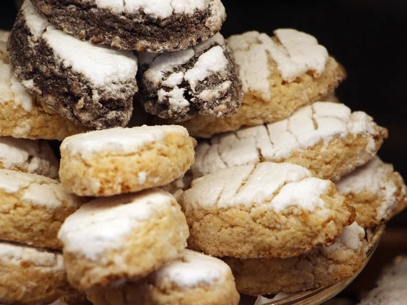 Ricciarelli all'olio extravergine di oliva appena preparati, disposti su un piano da lavoro