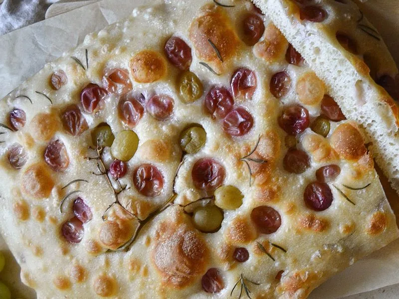 Schiacciata con uva, olio extravergine di oliva e rosmarino appena sfornata