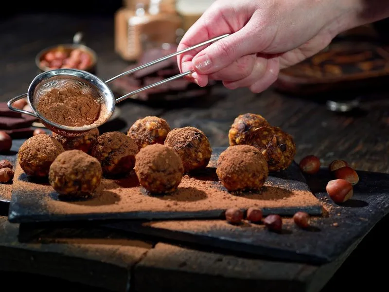 Truffles al cioccolato fondente arricchiti con olio extravergine di oliva, disposti su un piatto