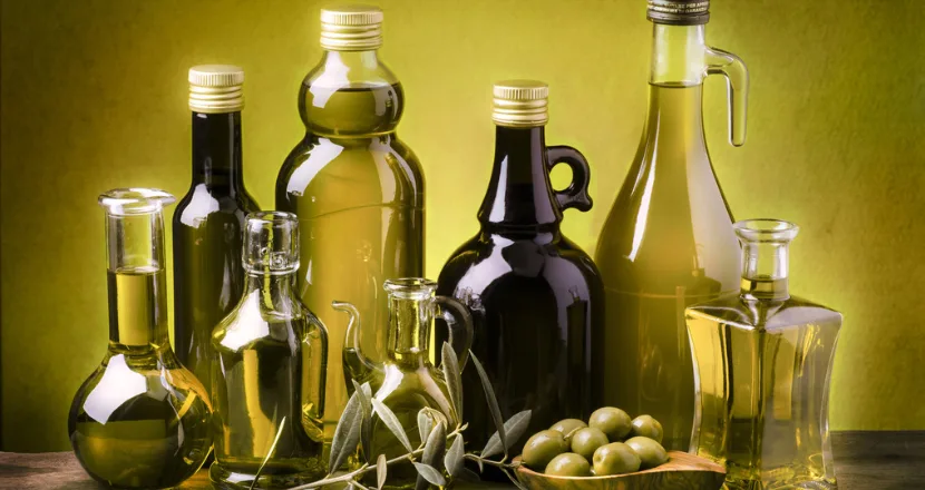 Bottiglie e frantoio di olio d'oliva, simbolo delle diverse tipologie e qualità